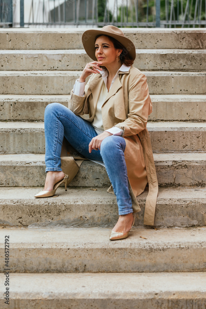 Thoughtful woman thinking about something while sitting on the stairs in the street. Thoughtful woman thinking about something while sitting on the stairs in the street.