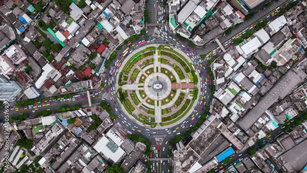 Top down aerial hyper lapse view of traffic around huge roundabout during rush hour in Bangkok, Thailand. 
