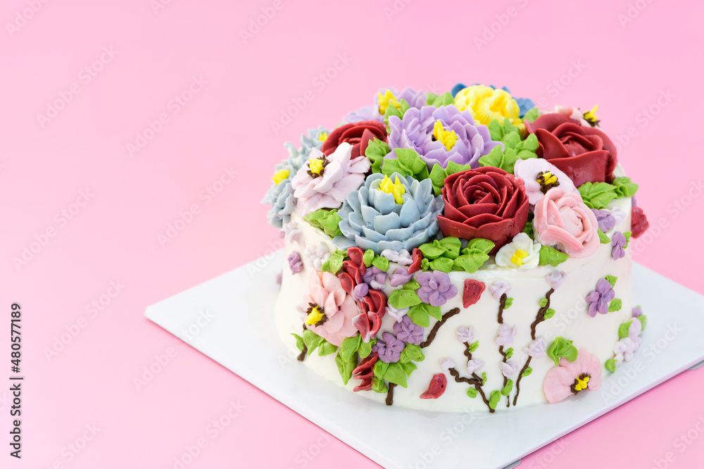 Homemade cake decorated with beautiful flowers on pink background,