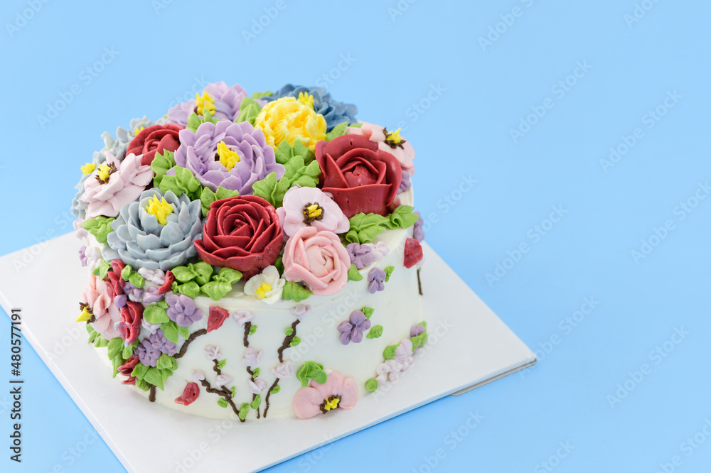 Homemade cake decorated with beautiful flowers on blue background, Homemade cake decorated with beautiful flowers on blue background,