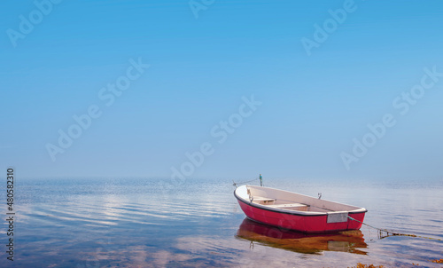 Rotes Ruderboot in einem ruhigen Gewässer