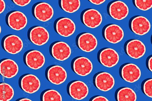 Minimal fruit pattern with grapefruit on blue  background. Creative  summer mood. Healty concept. Organic fruit. Flat lay. Trendy social mockup or wallpaper. photo