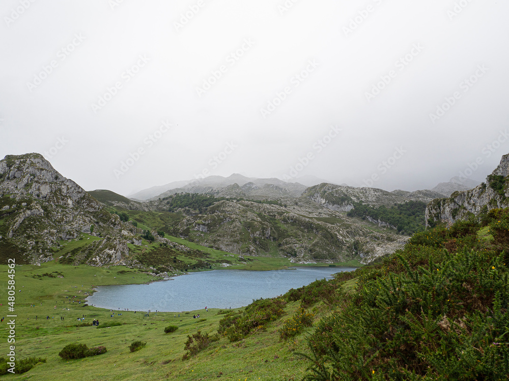 Paisaje natural nublado de los Lagos de Covadonga, en el verano de 2020, con montañas verdes, aguas turquesas y nubes blancas en el cielo azul, en España.