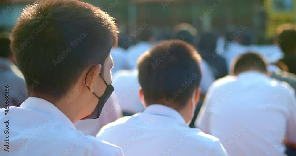 Slow motion scene in the morning while the Asian high school students in white uniform wearing the masks stand in line during the Coronavirus 2019 (Covid-19) epidemic. Slow motion scene in the morning while the Asian high school students in white uniform wearing the masks stand in line during the Coronavirus 2019 (Covid-19) epidemic.