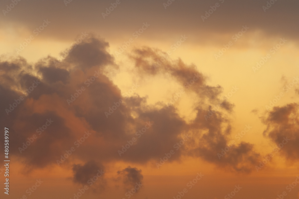 Dramatic view of a dark silhouettes of clouds in the orange sky