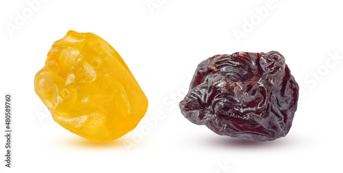 Close up view on a yellow and black raisins, isolated on a white background