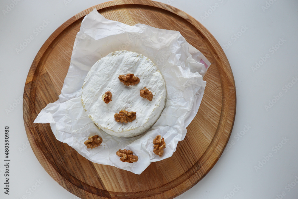 camembert cheese with honey and nuts on a wooden background camembert cheese with honey and nuts on a wooden background