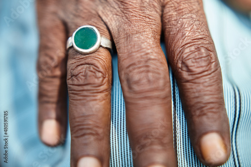Old man hand in detail with green ring on finger. The color of the ring could be related to Islam. Outside. Close Up.  © Patrick Ranz