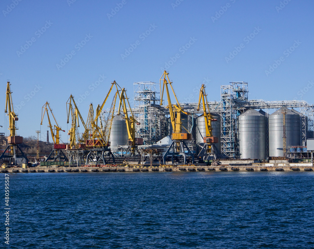 seaport on the seashore, industrial and cargo cranes on the background of the sea,