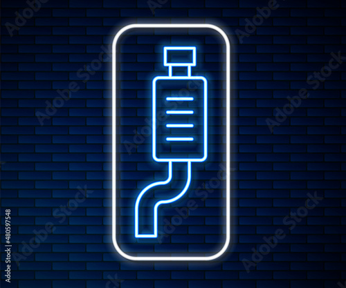 Glowing neon line Car muffler icon isolated on brick wall background. Exhaust pipe. Vector