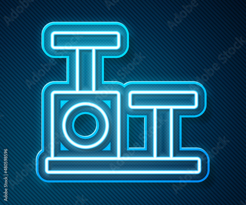 Glowing neon line Cat scratching post with toy icon isolated on blue background. Vector