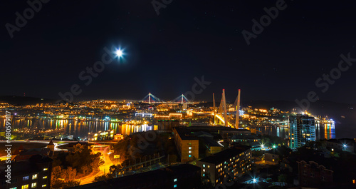 Panorama of Vladivostok at night with the Golden Bridge and the bridge Russian. Far East, Russia