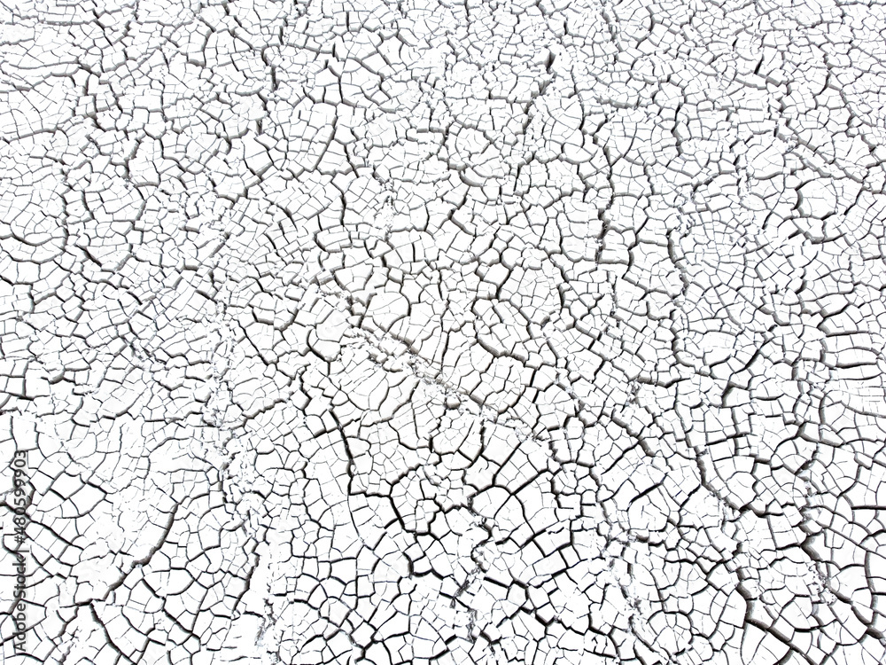 Cracked white surface. Crack surface on land. Dry desert cracks. Cracked soil ground in nature. Aerial drone view of material in tailings reservoir. Land contamination.