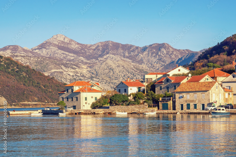 Calm sunny winter day. Beautiful Mediterranean landscape. Montenegro, Adriatic Sea, coast of Kotor Bay. Small seaside Lepetane village at foot of mountains