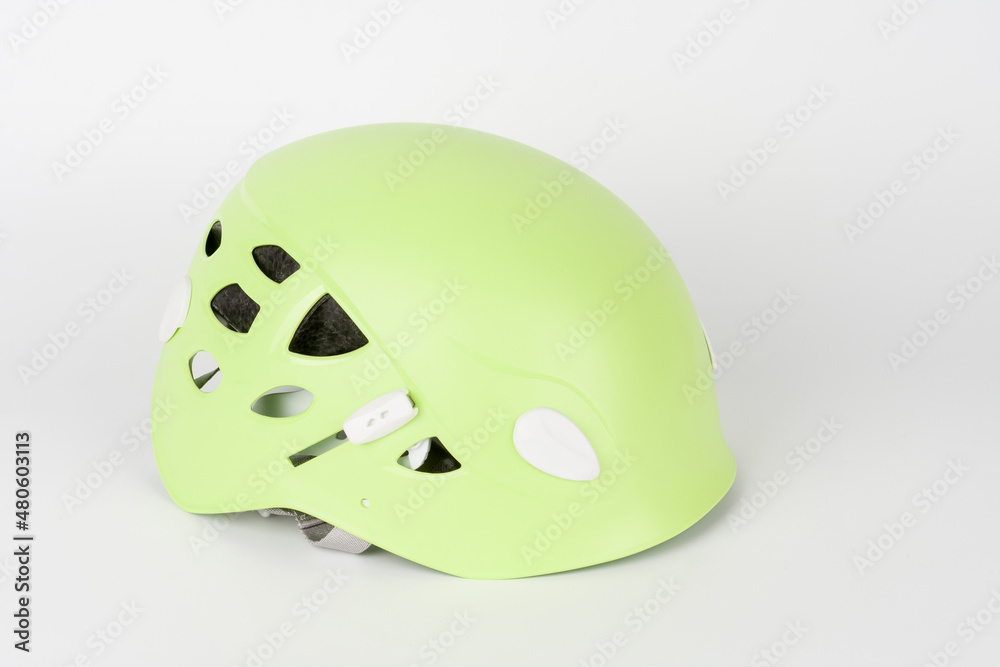 Fototapeta premium New green climbing helmet on white background.