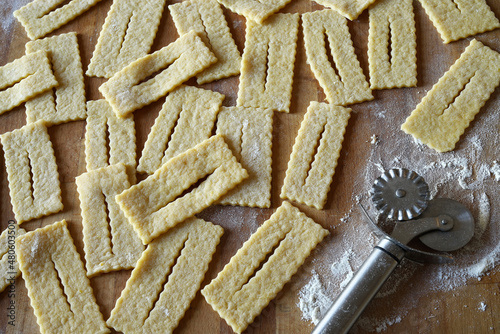 Dolci di carnevale italiani tradizionali fatti in casa freschi chiamati chiacchiere su tavola di legno infarinata. Direttamente sopra. photo