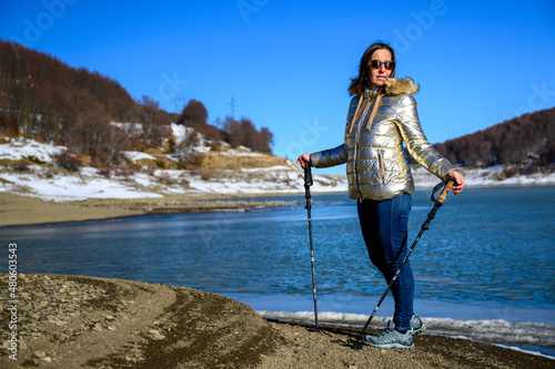 Escursionista bella donna con bastoncini e giacca oro © Giuliano Bianchini