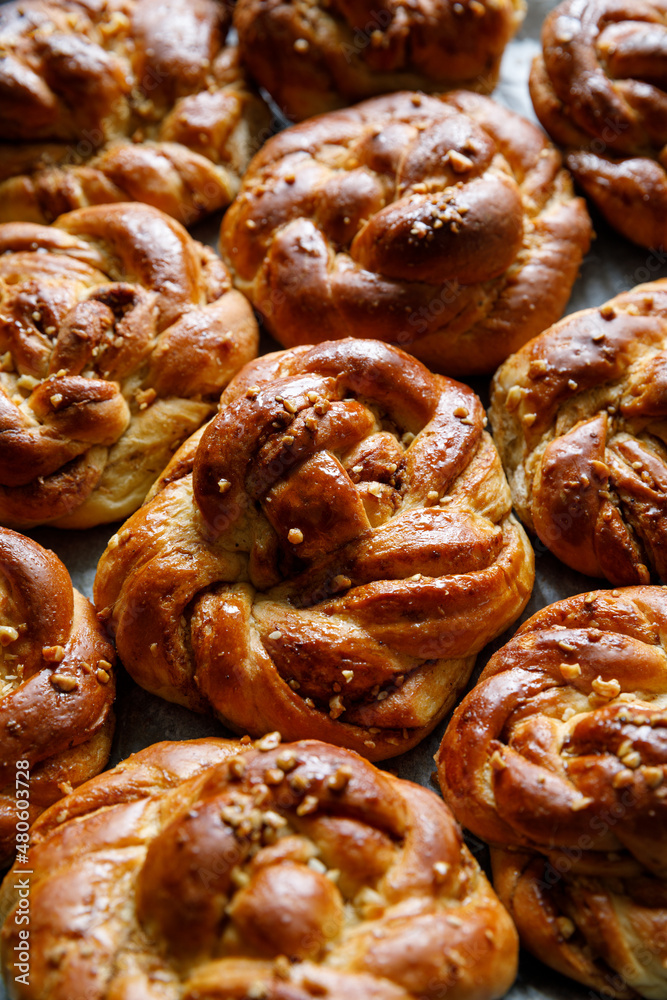 Homemade traditional cinnamon - cardamom sweet buns, close up view. Traditional Swedish baking Kanelbular.