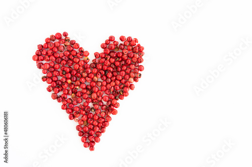 Isolated pink pepper in the shape of a heart on a white background, love of cooking