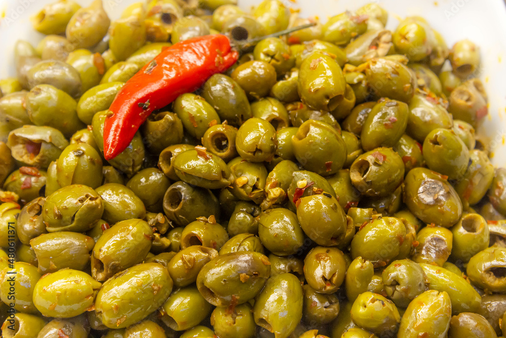 Green olive salad background with a chilli on top Green olive salad background with a chilli on top
