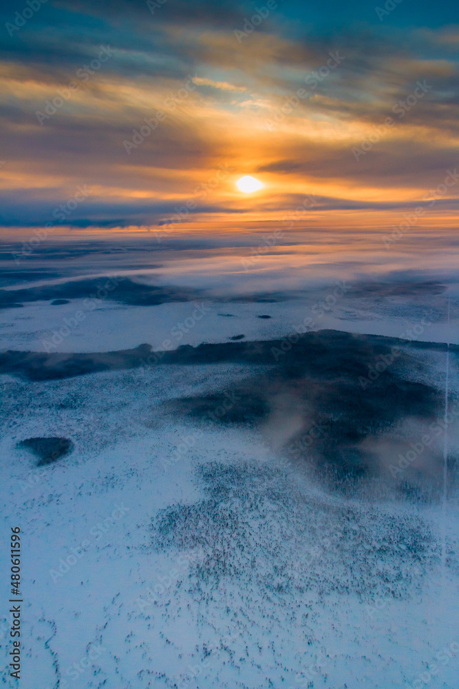 Fototapeta premium Aerial view of winter snowy countryside at sunrise