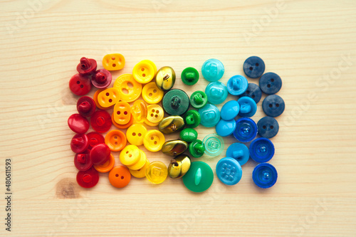 Multicolored buttons. Color rainbow buttons on wooden background