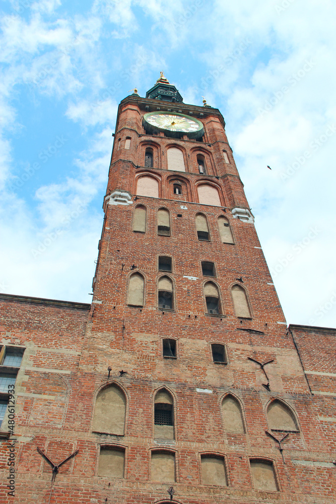 Antique red brick tower with wall clock in Gdansk. architecture of city building