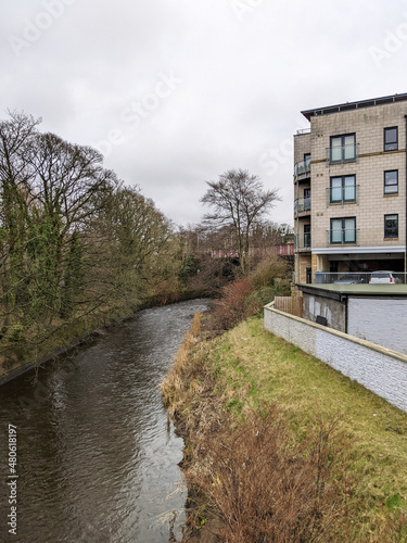 A river running next to an apartment building