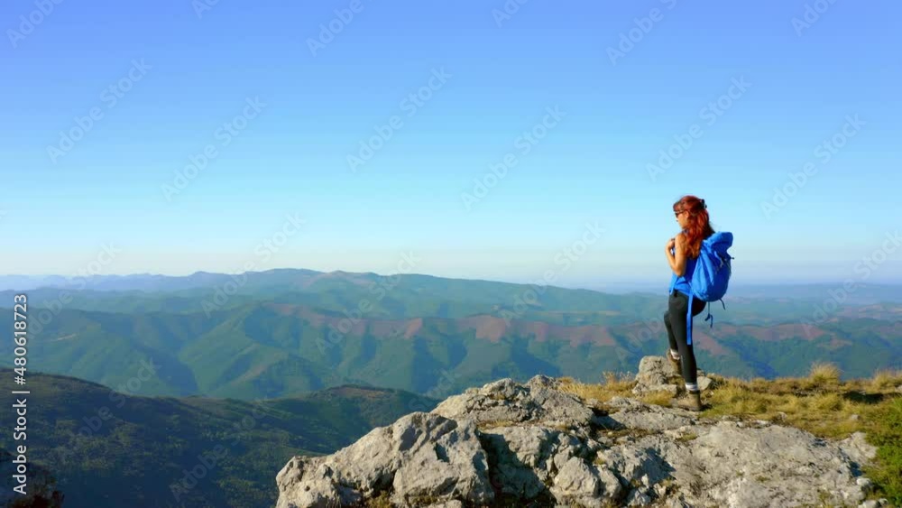 Aerial view of a woman on top of a mountain looking at the sunrise. Hiker girl celebrating scenic landscape enjoying nature vacation travel adventure. 4k Aerial view of a woman on top of a mountain looking at the sunrise. Hiker girl celebrating scenic landscape enjoying nature vacation travel adventure. 4k