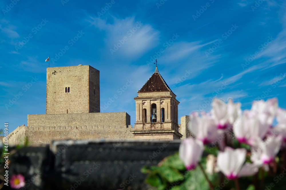 View of the tower of the castle of Alcaudete (Jaén, Spain) behind the church of Santa María la Mayor