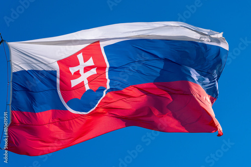 Slovak national flag, large flag of Slovakia in high resolution flown against blue sky photo