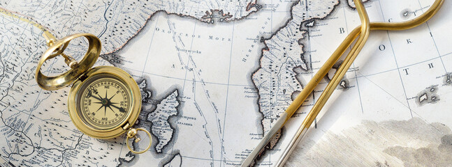 Retro styled golden compass (sundial), antique vintage W & HC 6" brass dividers calipers nautical navigation chart tool and old white map close-up. Vintage still life. Sailing accessories