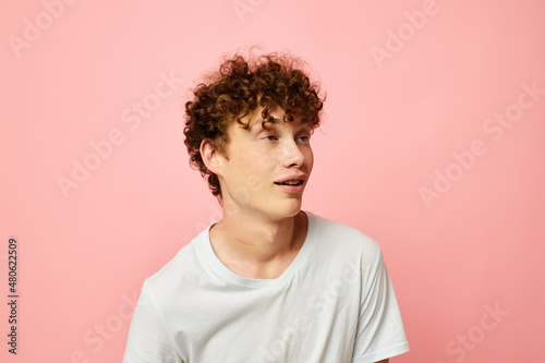 portrait of a young curly man posing youth style white t-shirt isolated background unaltered