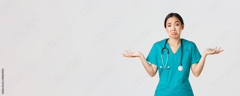 Covid-19, healthcare workers, pandemic concept. Portrait of clueless asian female nurse, woman doctor shrugging and spread hands sideways unaware, dont know, cant help, white background - obrazy, fototapety, plakaty 