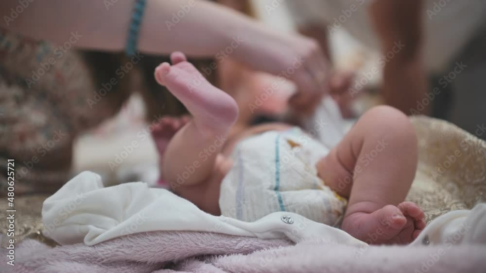 A mother changing her newborn baby girl's diaper. A mother changing her newborn baby girl's diaper.
