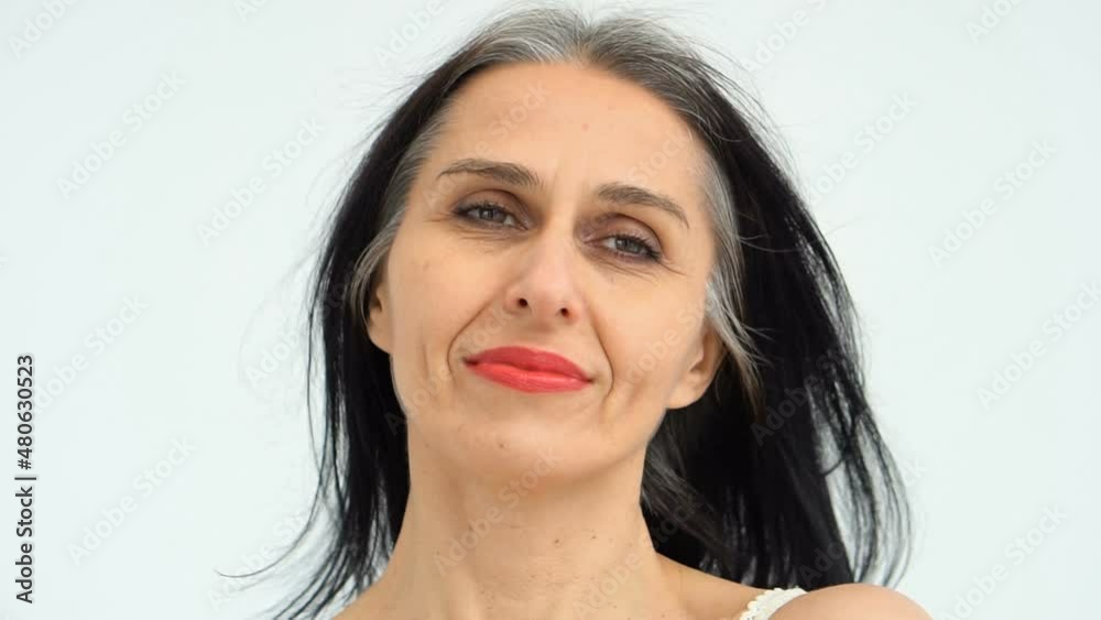 Female portrait of middle aged woman starting getting grey-haired in studio with naked shoulders on white background, face skin care beauty, middle age skincare cosmetics, cosmetology concept Female portrait of middle aged woman starting getting grey-haired in studio with naked shoulders on white background, face skin care beauty, middle age skincare cosmetics, cosmetology concept