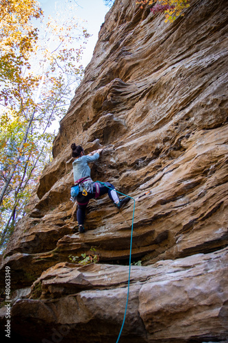 woman rock climbing in the fall 