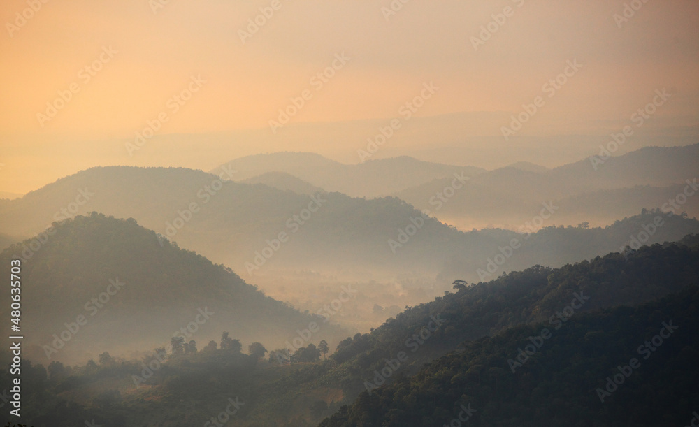 Mountain range with visible silhouettes through the morning colorful fog.with sunlight romanctic moment