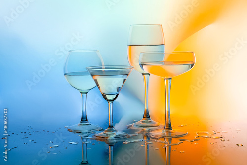 Glass glasses with white wine on a multicolored background