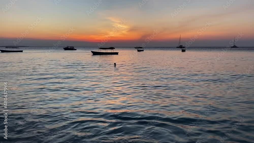 Sunset on the horizon of the Indian ocean with small waves and small boats floating. Sunset on the horizon of the Indian ocean with small waves and small boats floating.