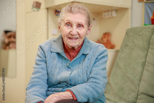 Grandmother alone at home, loneliness, an old woman with a wrinkled face in the room, caring for the older generation, great-grandmother. 