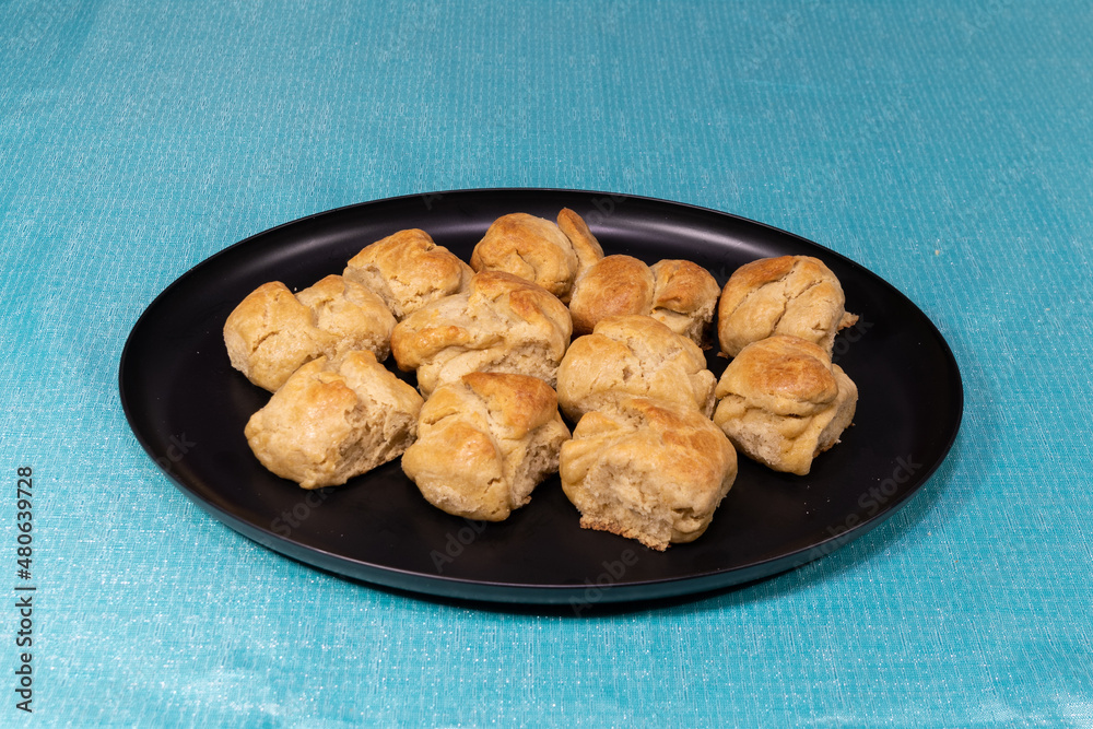Fresh baked biscuits filling a black plate on a table Fresh baked biscuits filling a black plate on a table