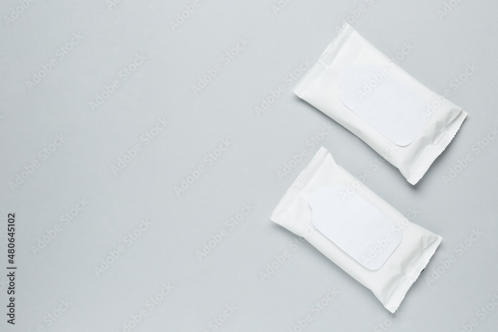 Wet wipes flow packs on light grey background, flat lay. Space for text Wet wipes flow packs on light grey background, flat lay. Space for text