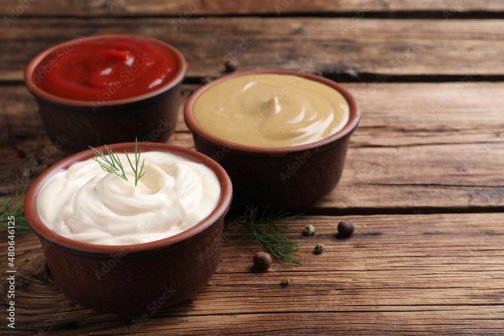 Many different sauces on wooden table, space for text Many different sauces on wooden table, space for text