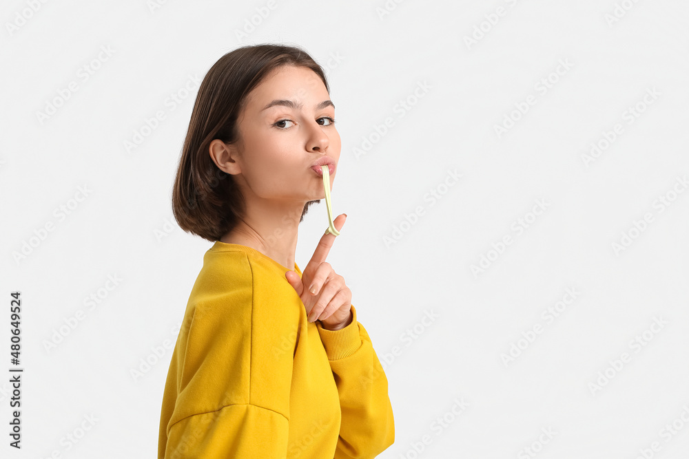 Young woman with chewing gum on light background Young woman with chewing gum on light background