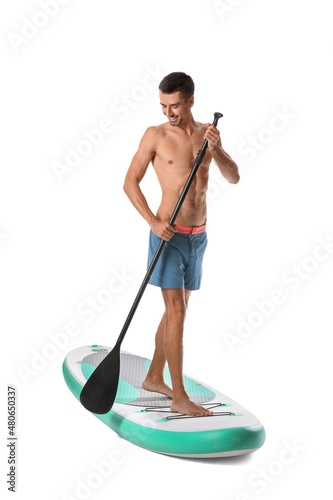 Photography Handsome young man with board for sup surfing and oar on white background