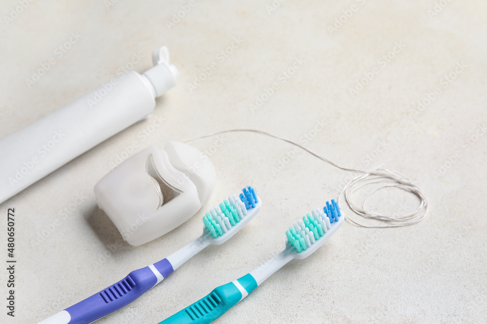 Dental floss with tooth brushes and paste on white background Dental floss with tooth brushes and paste on white background
