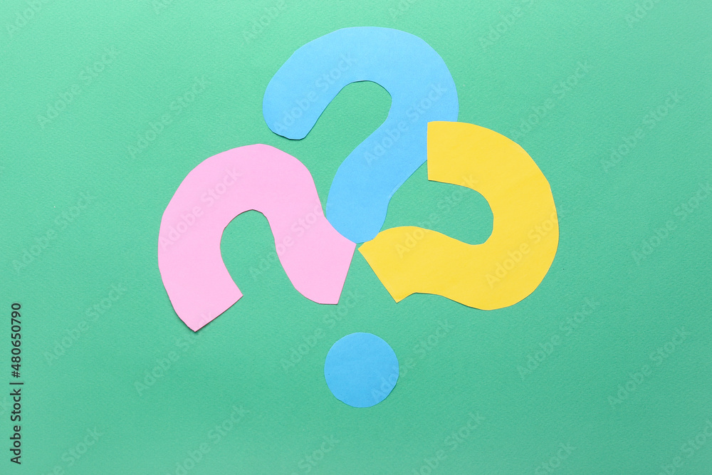 Question marks made of paper on green background Question marks made of paper on green background