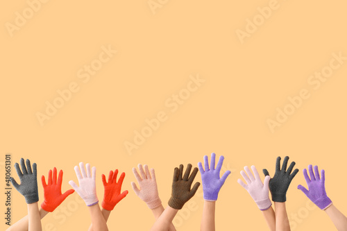 Women in warm gloves on beige background