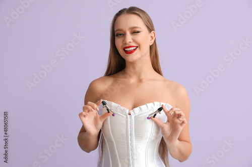 Fotografie Attractive woman with nipple clamps from sex shop on color background
